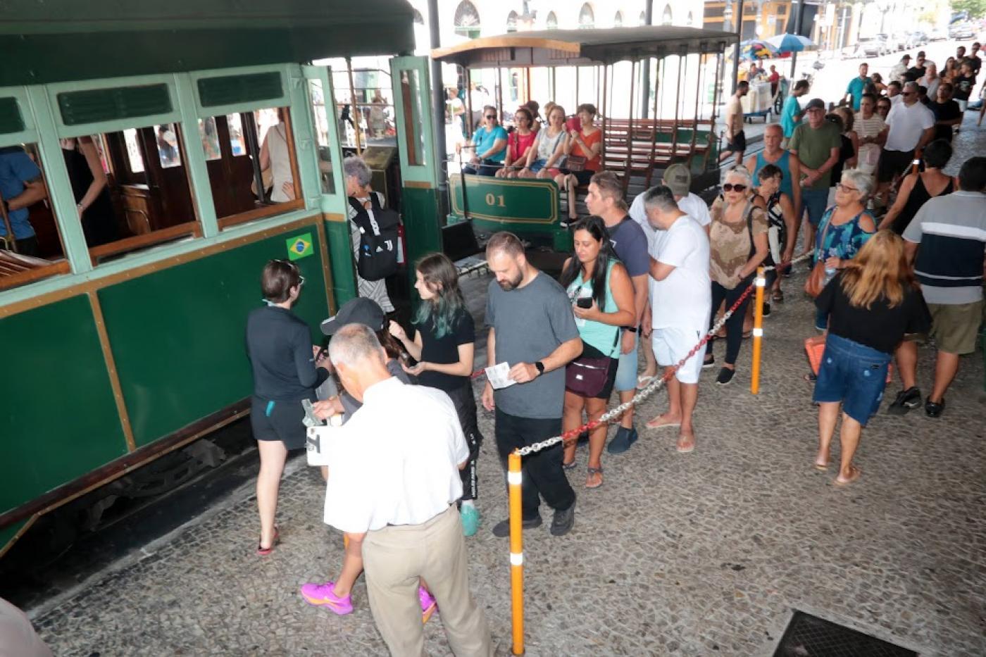 Fila de pessoas para embarque no bonde, em frente à Estação do Valongo