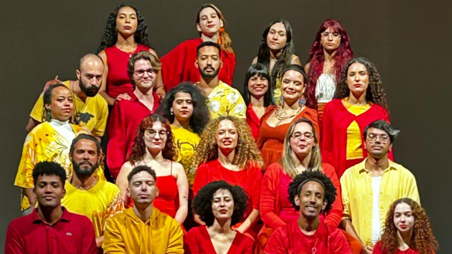 Alunos do curso de teatro vestindo roupas vermelhas e amarelas.