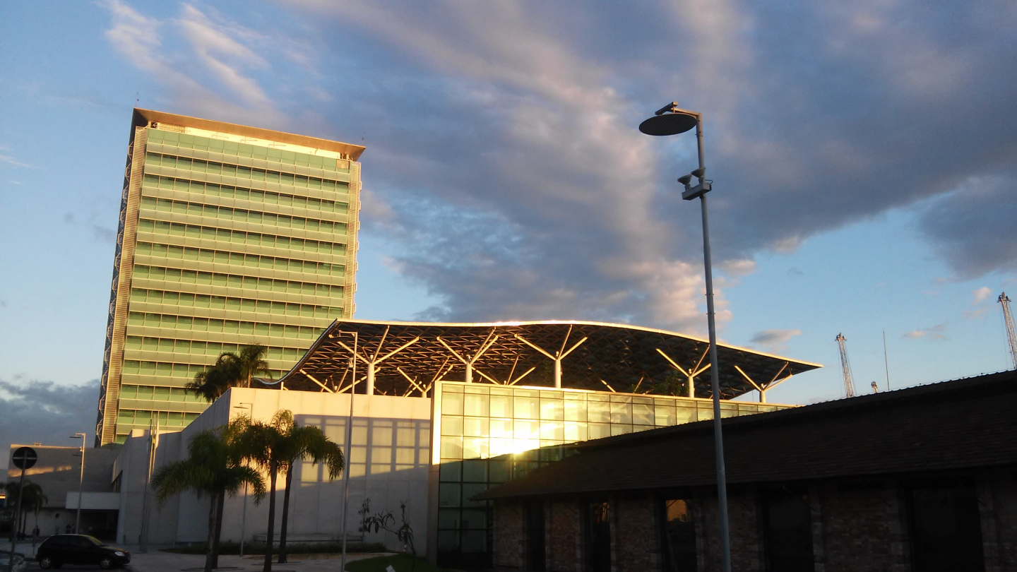 O moderno edifício de vidro e estrutura metálica da Petrobras (EDISA) se destaca sob um céu nublado durante o entardecer