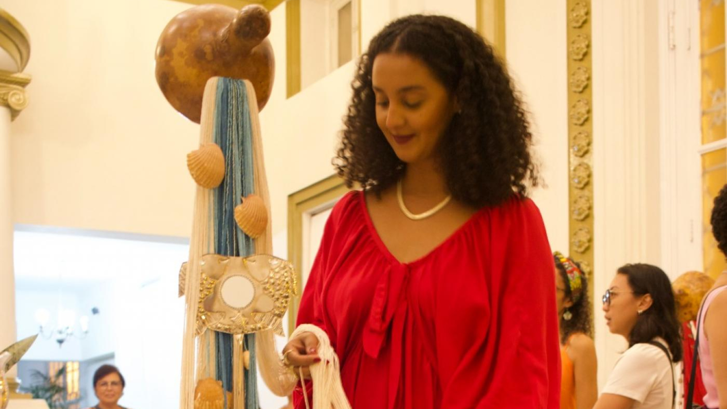 Mulher segurando detalhe da exposição