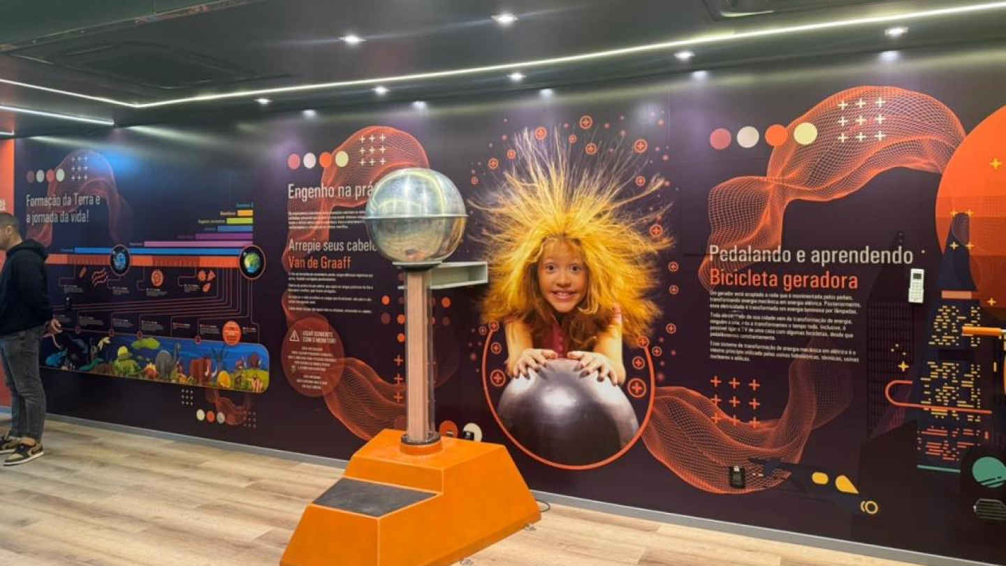 Exposição itinerante do Museu Catavento apresentando um gerador de Van de Graaff e painéis educativos sobre ciência e energia