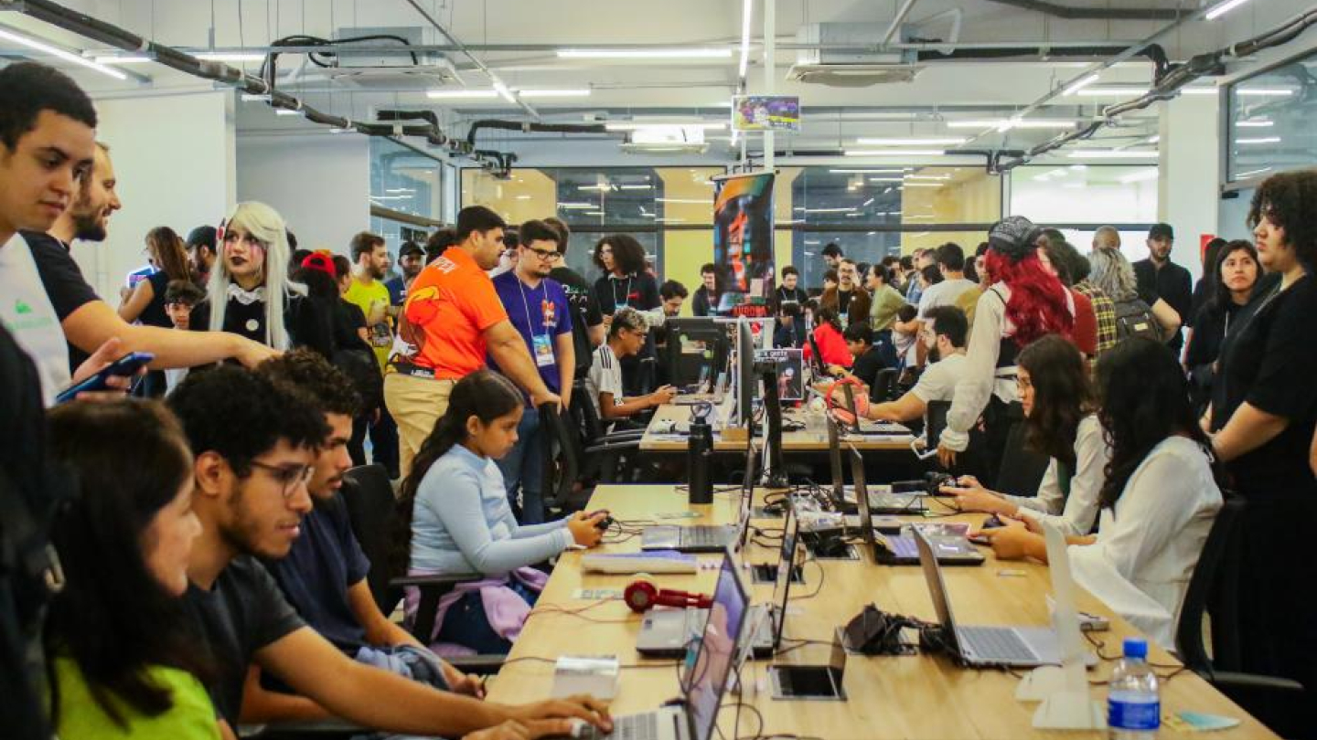 Diversos jovens usando laptops em evento tecnológico