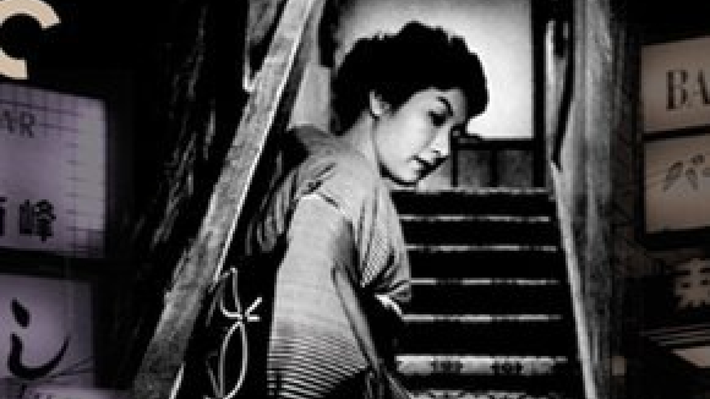 Pôster em preto e branco do filme When a Woman Ascends the Stairs. Uma mulher de quimono olha para trás enquanto sobe uma escada estreita, cercada por placas com caracteres japoneses, em uma composição que transmite um clima urbano e intimista.