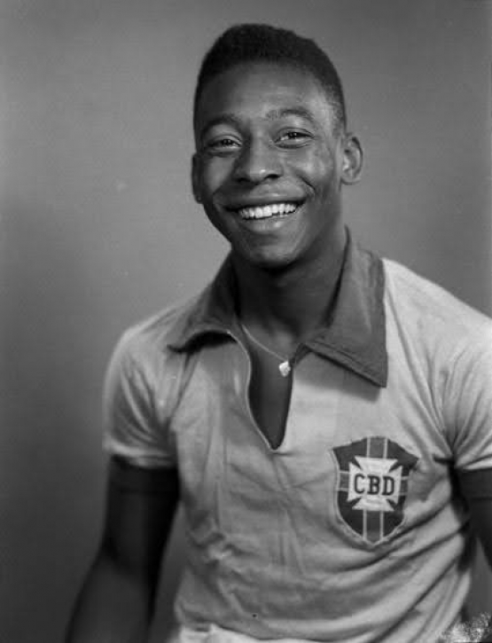 Fotografia em preto e branco do jovem Pelé. Ele veste a camisa clara da Seleção Brasileira, com o escudo da antiga CBD estampado no peito.
