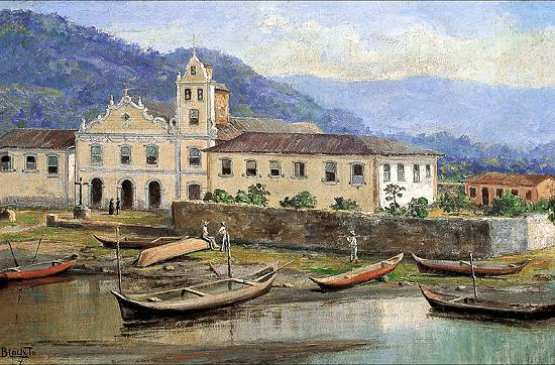 Uma pintura que retrata uma paisagem costeira. Em primeiro plano, pequenas embarcações de madeira flutuam na água calma ou estão ancoradas na margem lamacenta. Ao fundo, um complexo de edifícios claros com uma igreja de fachada ornamentada e uma torre sineira alta domina a cena. Montanhas azuladas elevam-se ao longe, sob um céu parcialmente nublado