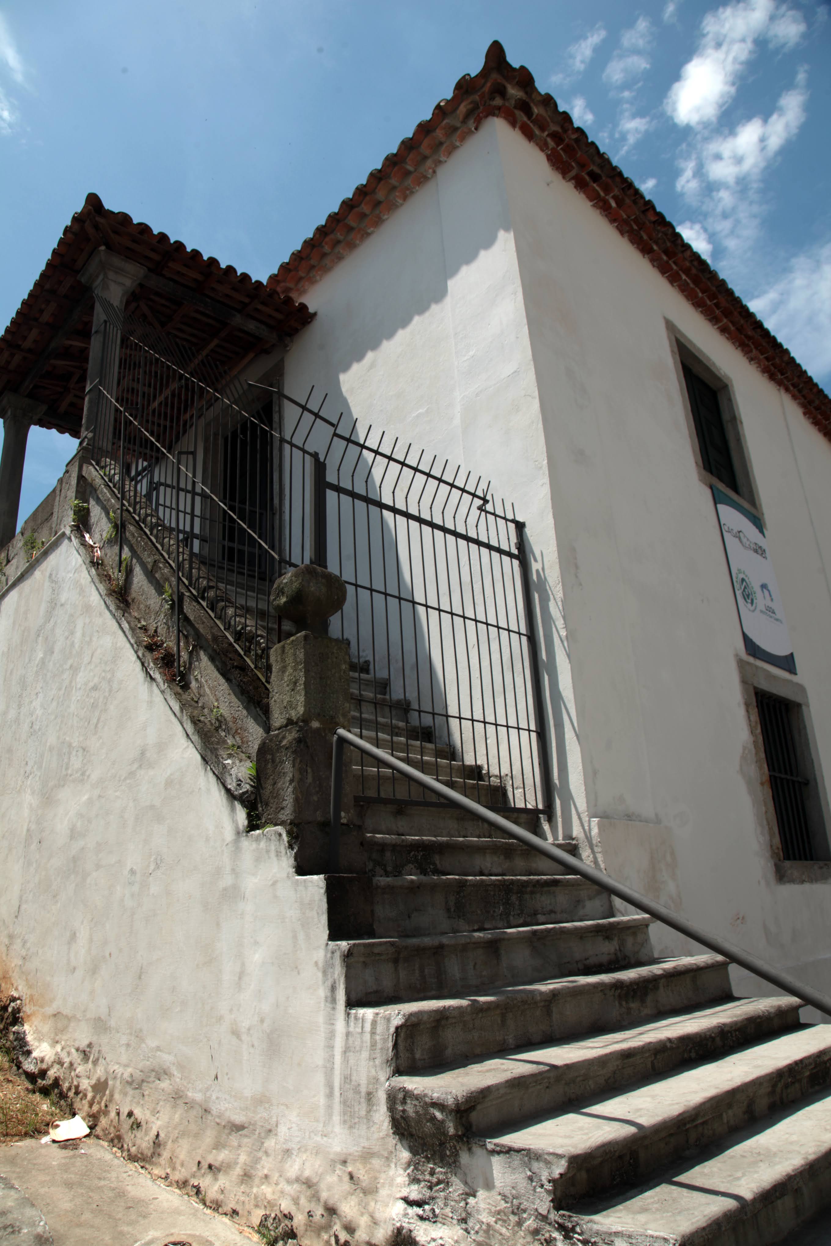Escadaria externa ao lado de uma construção branca de dois andares