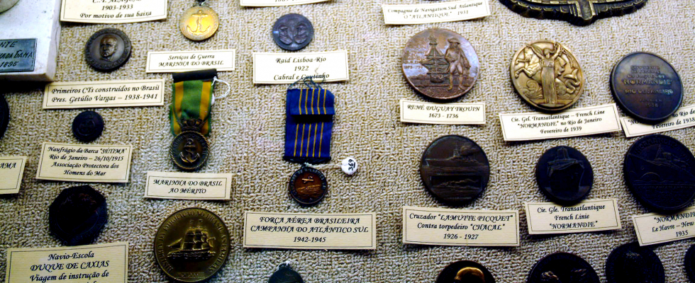 Acervo de medalhas de cores, formados e materiais variados.