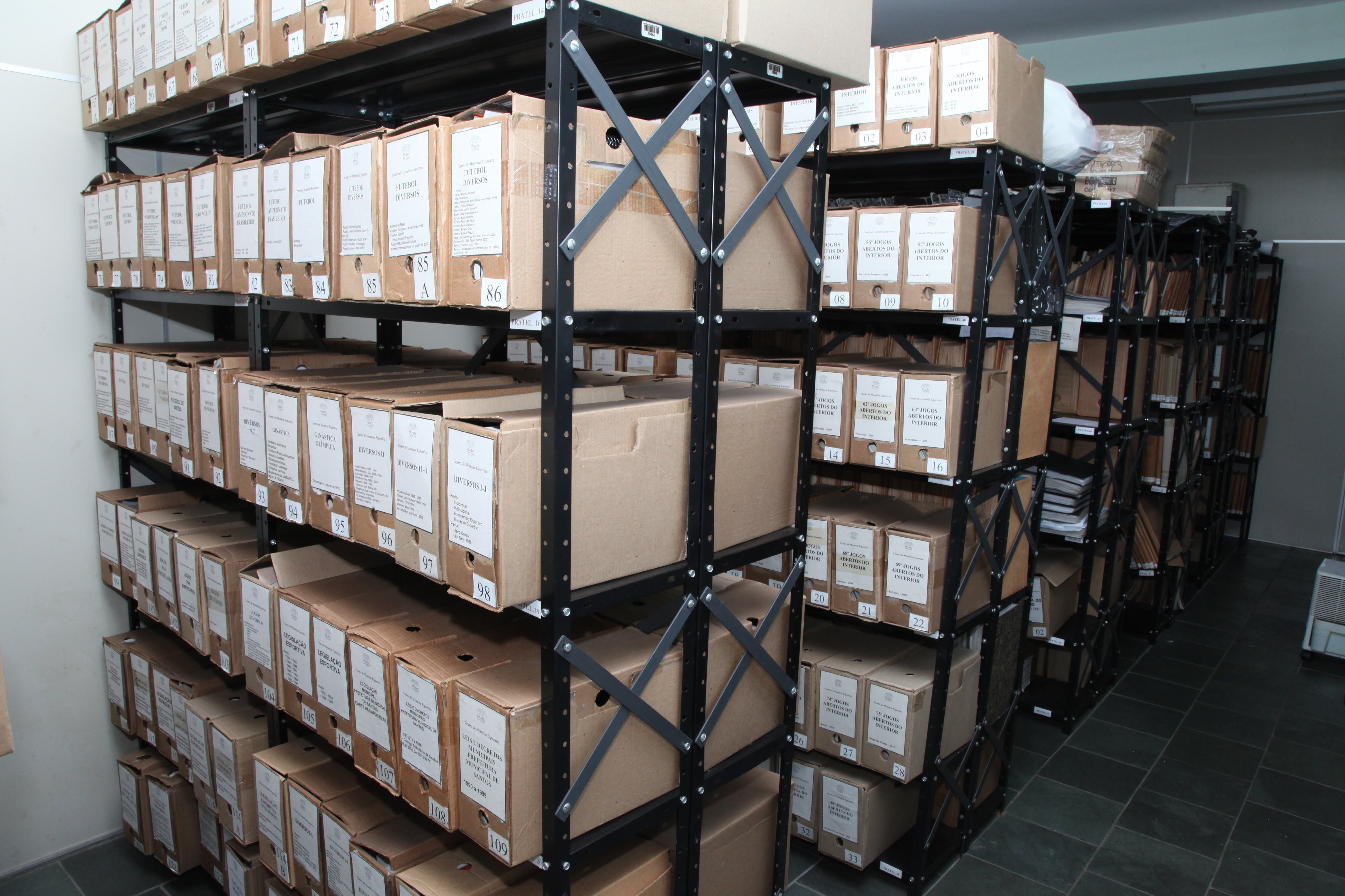 Metal shelves organize numerous file boxes containing historical documents and records