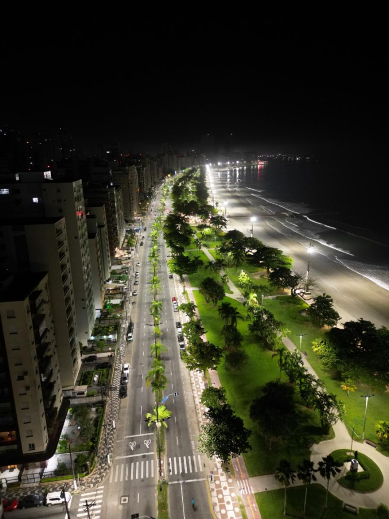 Foto aérea da Orla de Santos à noite, mostrando jardim e avenida da praia vazia