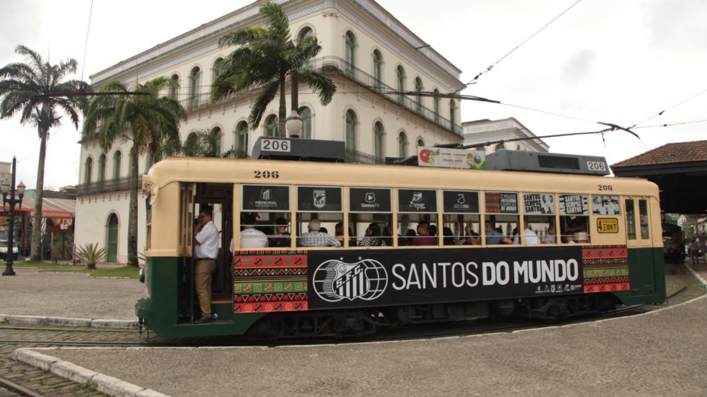 bonde branco e verde em frente ao prédio branco do museu pelé