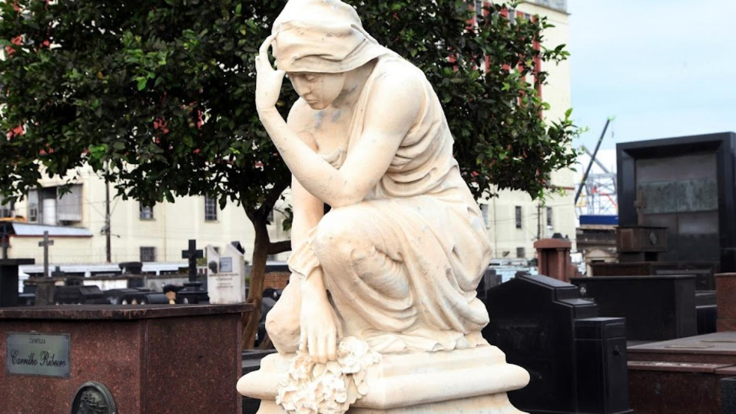 Escultura de mulher em posição pensativa, feita em mármore branco, localizada no cemitério do Paquetá