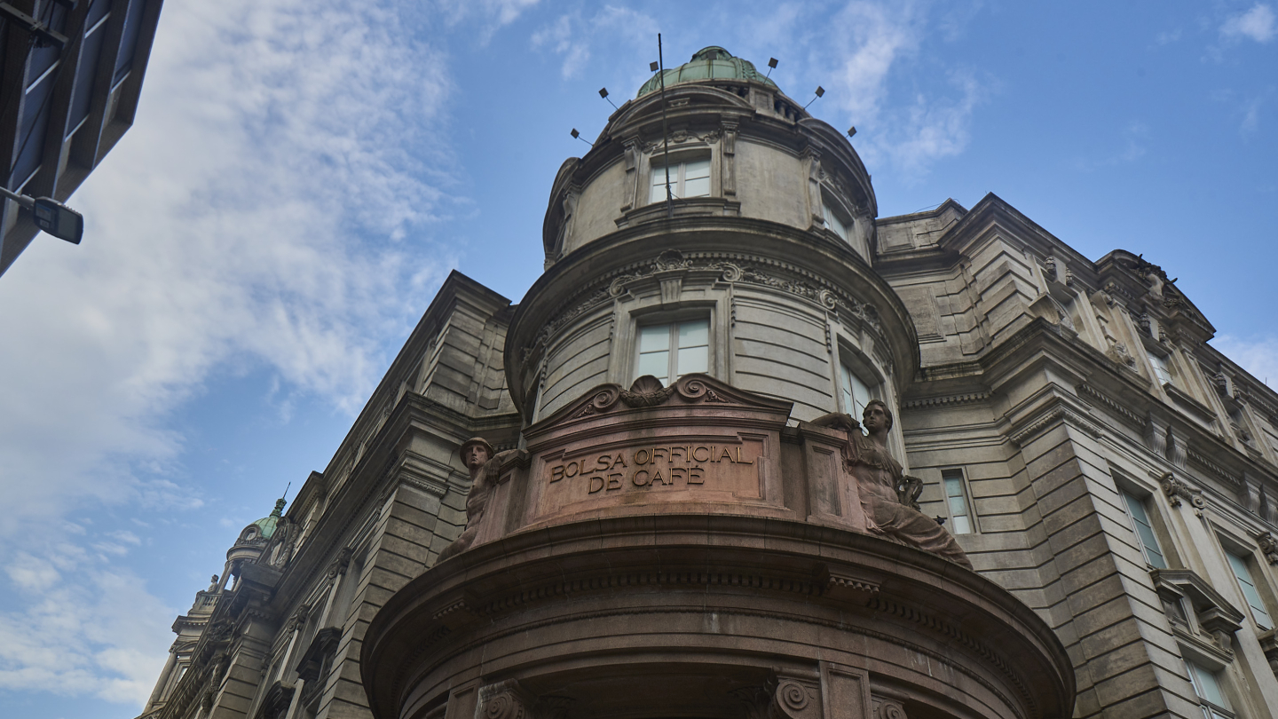 Fachada do edifício da Bolsa de Café, com céu azul ao fundo