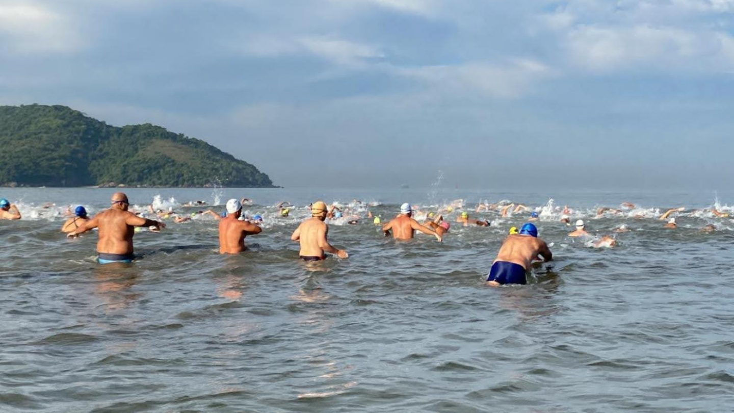 Diversos atletas nadando na orla de Santos