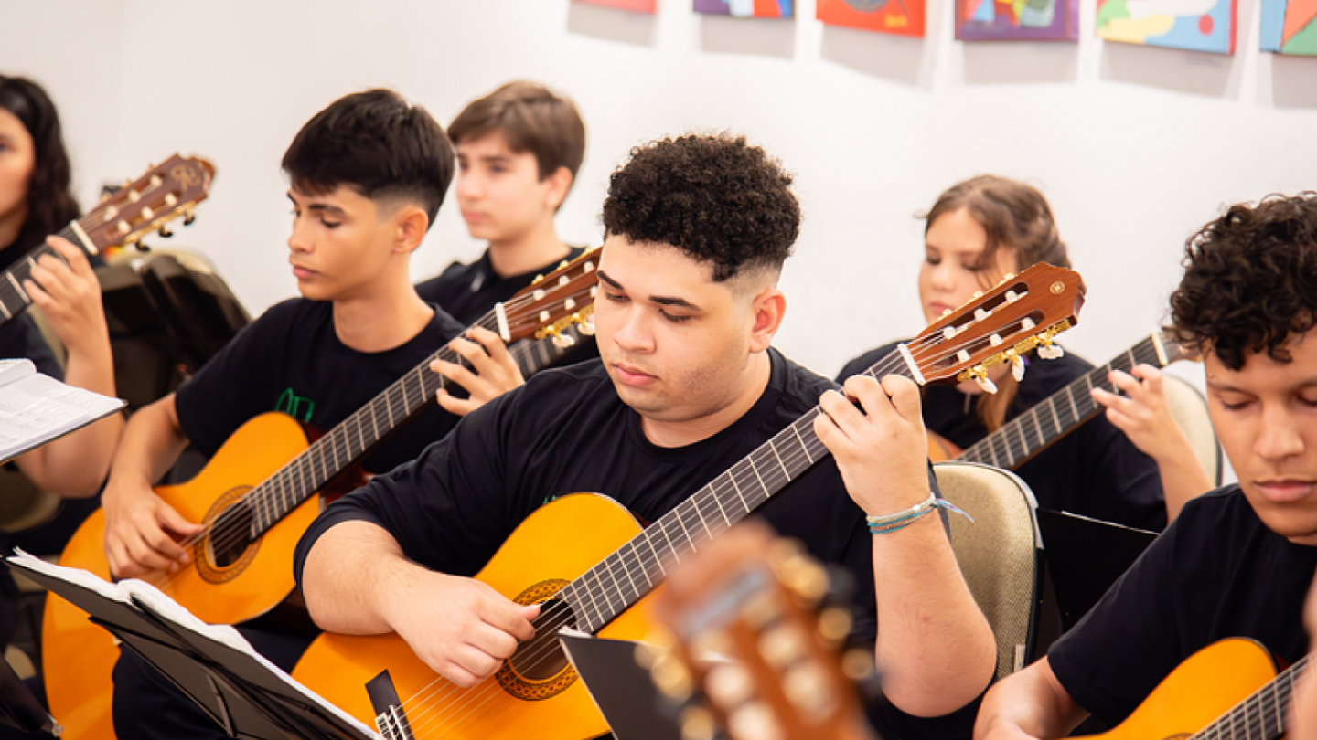 Pessoas jovens tocando violão