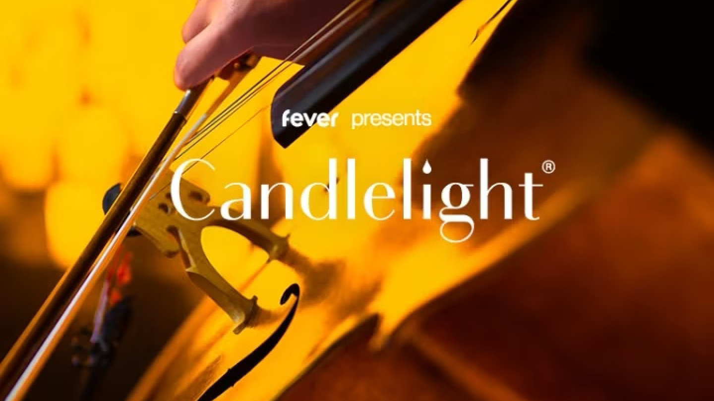 Close de uma mão tocando um violoncelo, com uma iluminação dourada intensa