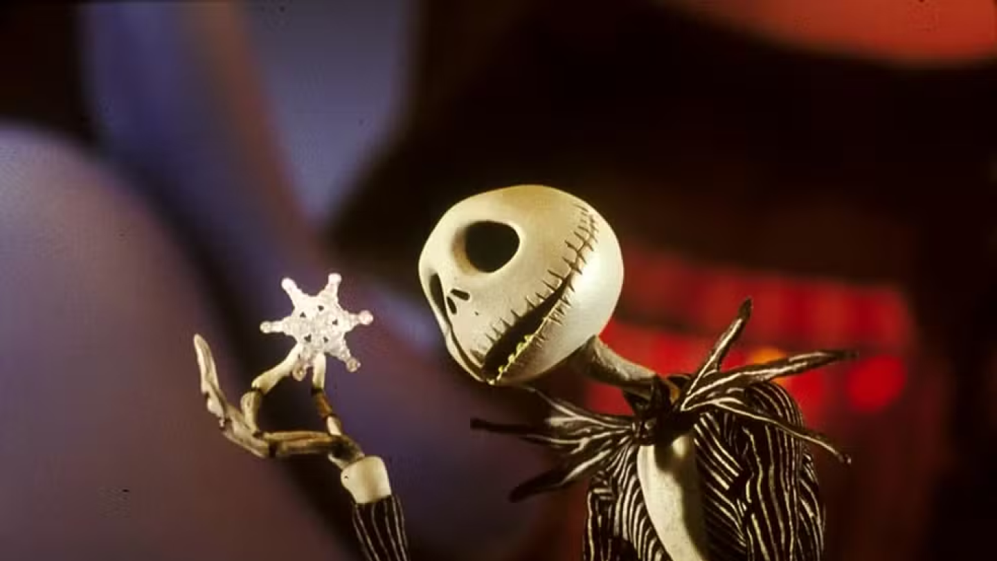 Personagem esquelético sorri segurando um floco de neve