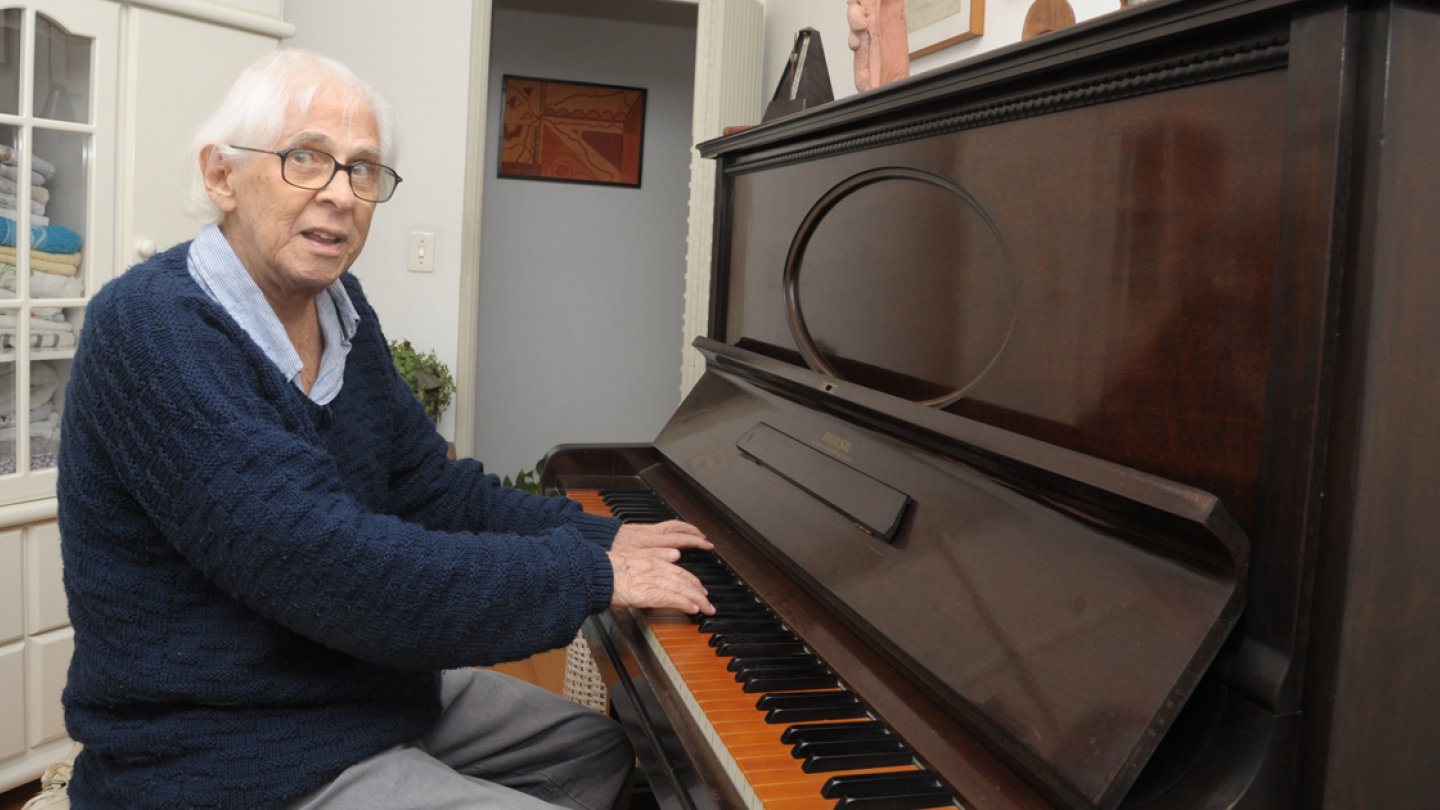 Gilberto Mendes sentado ao piano