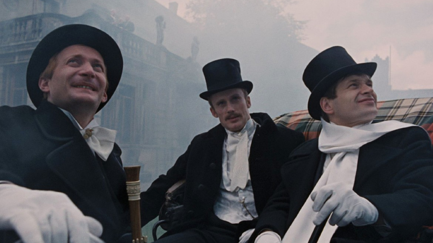 Três homens vestidos com trajes de gala e cartolas estão sentados em uma carruagem, cercados por névoa e um prédio ao fundo
