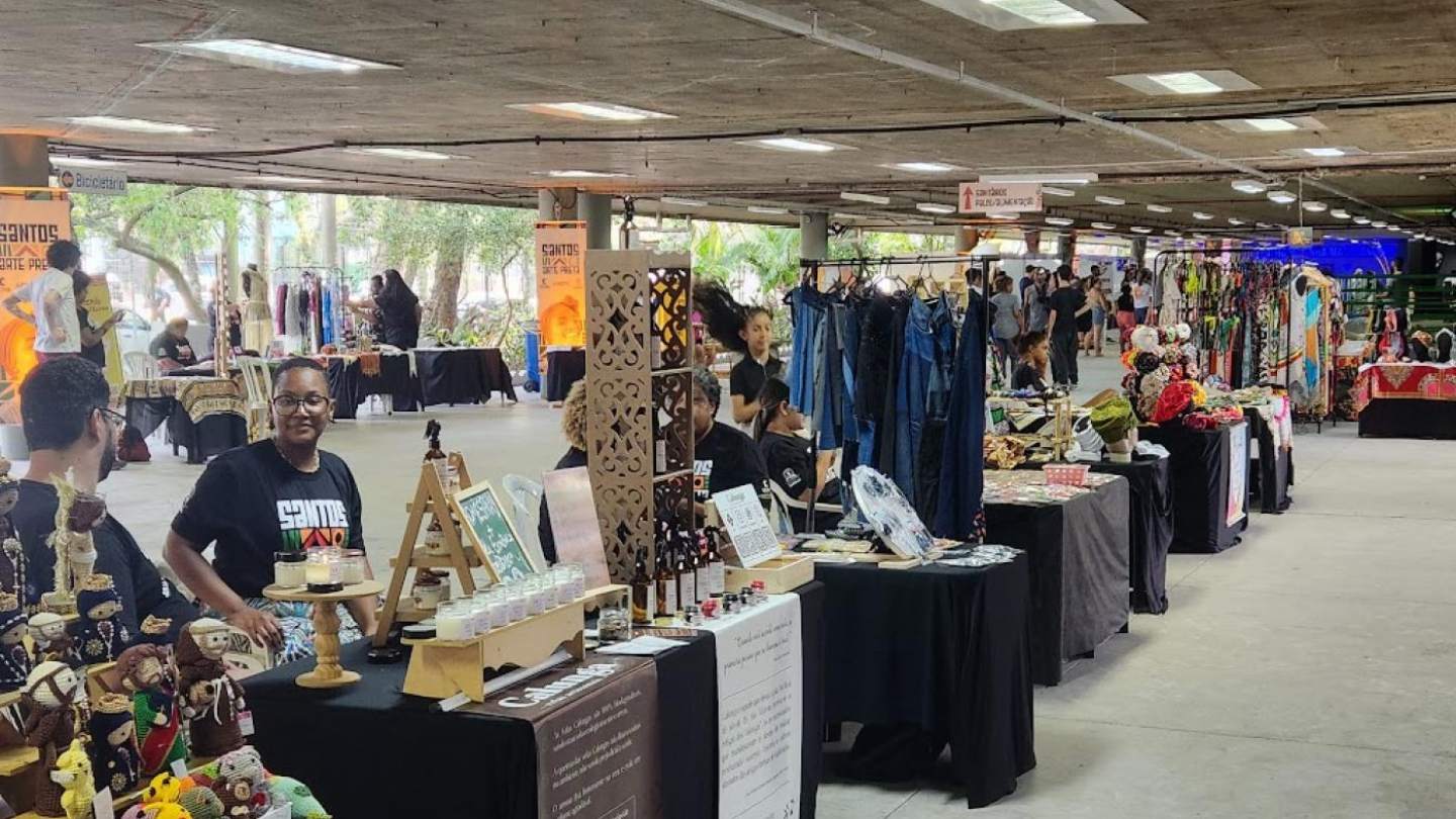 Uma feira de arte afro, com diversas barracas vendendo artesanato, roupas e outros produtos