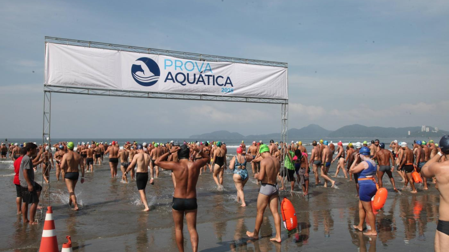 Uma grande quantidade de atletas entra no mar para participar da Prova Aquática Cidade de Santos