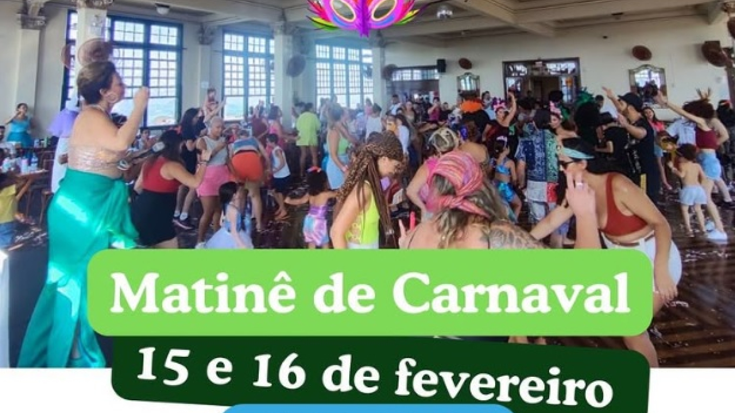 Pessoas fantasiadas dançam e celebram em um salão amplo durante um evento de Carnaval infantil