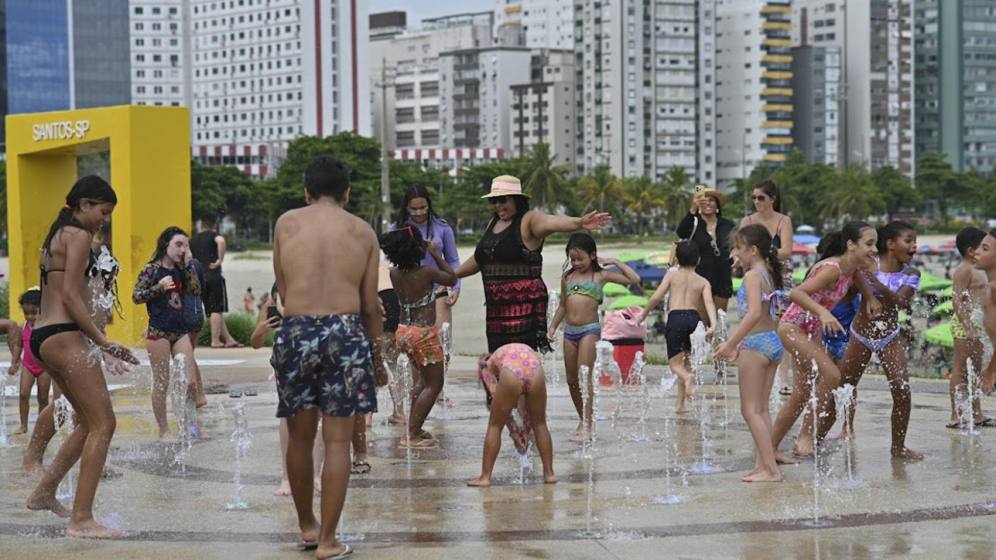 Orla da praia repleta de pessoas