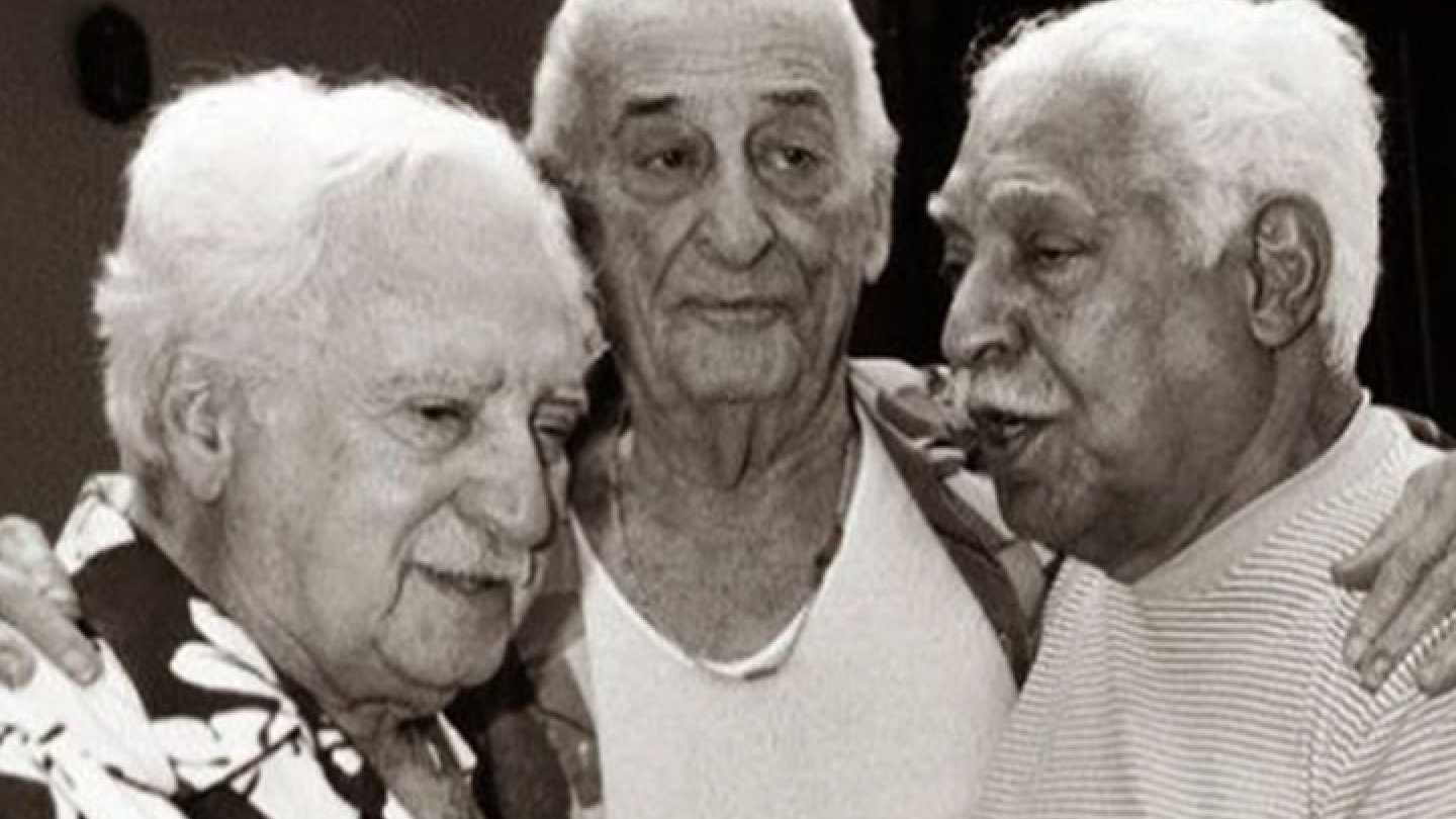 Fotografia em preto e branco que registra um momento de afeto e proximidade entre os escritores Jorge Amado, Carybé e Dorival Caymmi