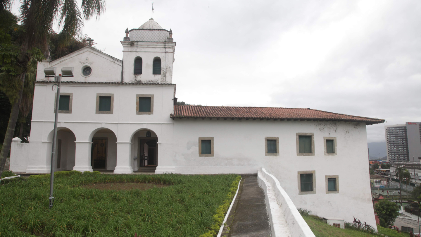 Fachada externa da histórica Igreja e Convento de Nossa Senhora do Desterro (atual Mosteiro de São Bento), em Santos, exibindo sua arquitetura colonial branca sob um céu nublado