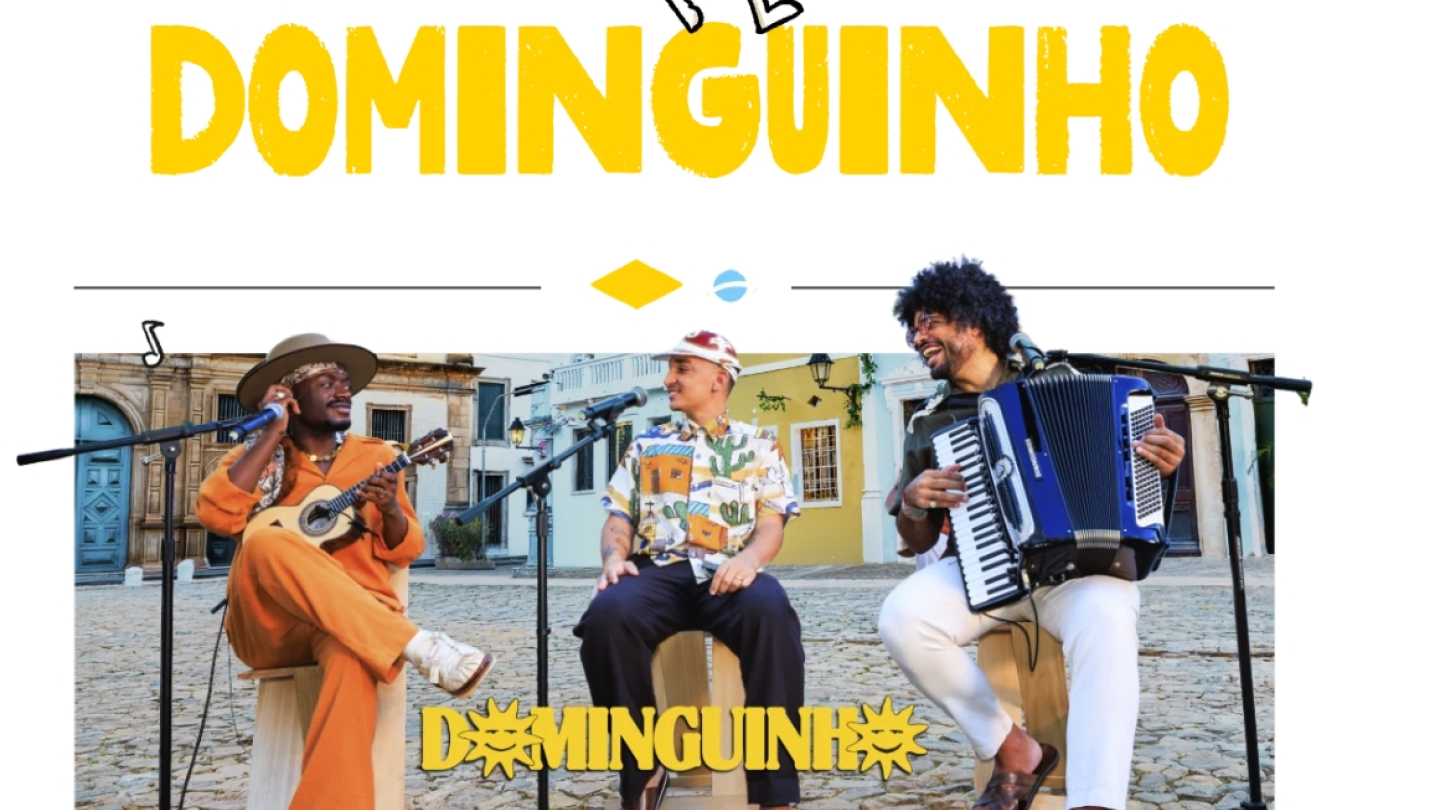 Arte de divulgação da turnê Dominguinho, com destaque para os artistas Jota.pê, João Gomes e Mestrinho. Os três aparecem sentados em um cenário ao ar livre, cercados por casarões históricos, cada um com seu instrumento: violão, cajón e sanfona. O título da turnê ocupa a parte superior da imagem em letras grandes nas cores preta e amarela, transmitindo um clima leve e festivo que remete às raízes da música nordestina.