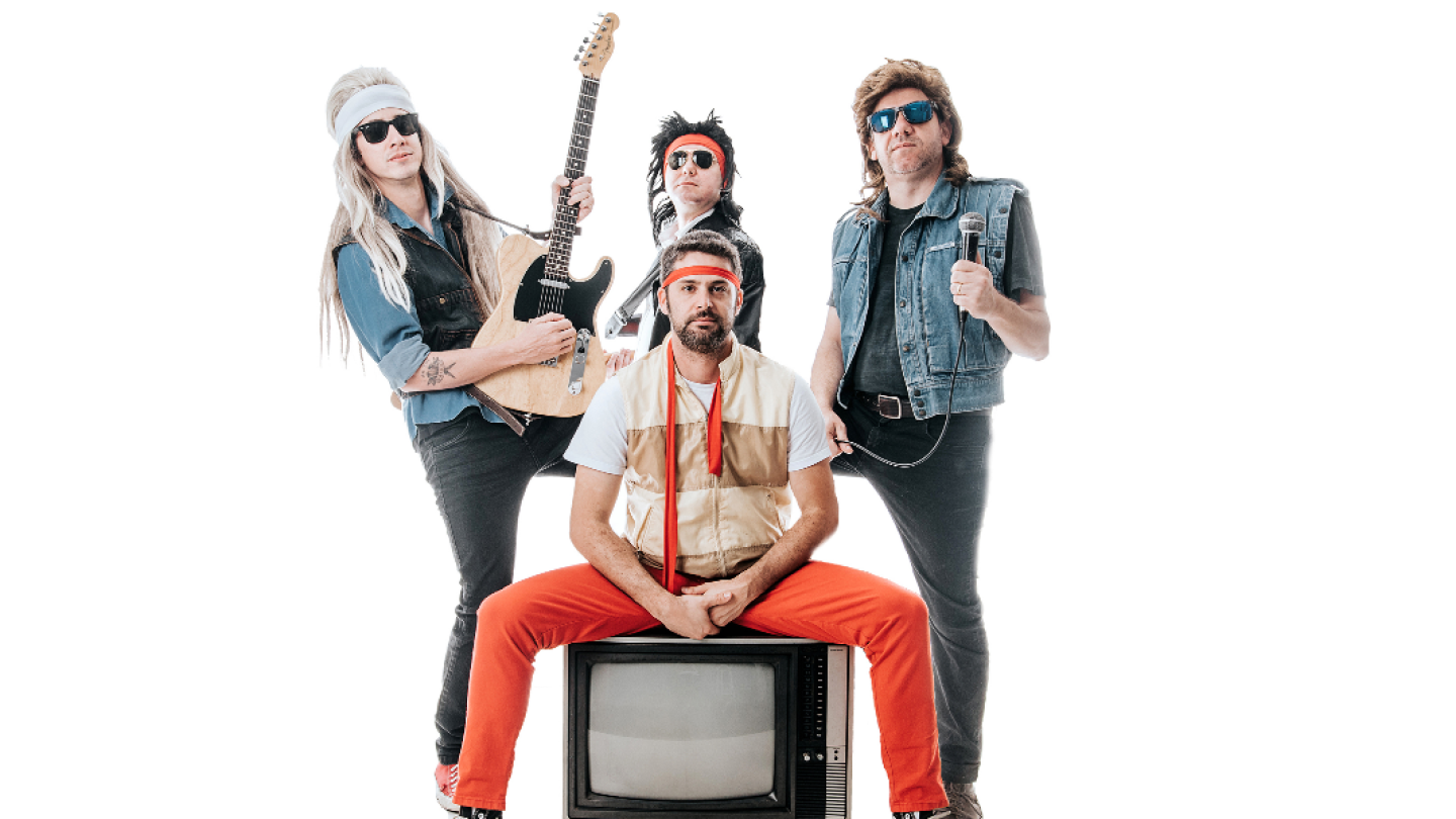 Fotografia promocional de uma banda formada por quatro integrantes caracterizados com figurinos inspirados no rock das décadas de 1980 e 1990. Ao centro, um integrante está sentado sobre um televisor antigo, vestindo calça vermelha, colete bege e faixa na cabeça. Atrás dele, os demais músicos posam usando perucas, óculos escuros, bandanas e coletes jeans; um segura uma guitarra e outro um microfone. A imagem possui fundo branco, destacando o visual retrô e bem-humorado do grupo, que remete à estética das ba